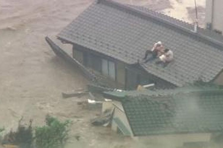 Warga Jepang menyelamatkan diri ke atap rumah setelah tempat mereka diterjang banjir.