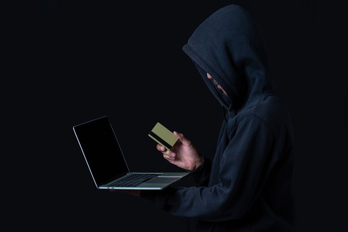 The concept of cyber theft. Hackers holding gold smart cards and white notebooks on a black backgroundIlustrasi hacker (Dok. Bank Danamon)