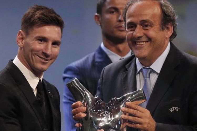 Striker Barcelona Lionel Messi (kiri) menerima trofi Pemain Terbaik Eropa 2014-15 dari Presiden UEFA Michel Platini saat acara pengundian fase grup Liga Champions di Monako, Kamis (27/8/2015).