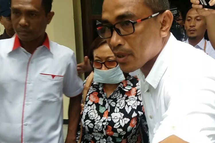 Mantan kepala BPKAD Kota Kendari, Fatmawati Faqih memakai masker dikawal polisi seusai pemeriksaan KPK di Polda Sultra.