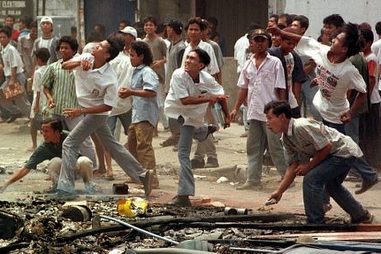 Aksi para perusuh yang melemparkan batu ke sebuah toko milik etnis Tionghoa di Medan, Sumatera Utara, pada 6 Mei 1998.