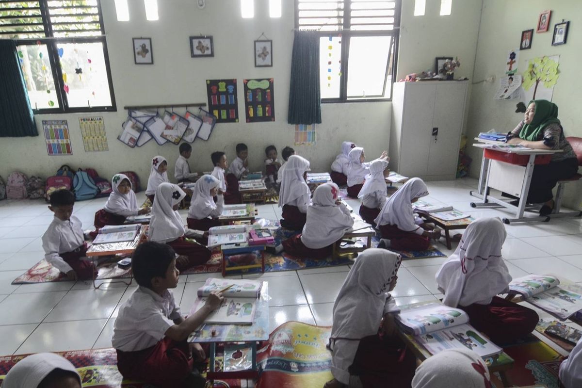 Para murid di kelas 2 SDN Pekayon Jaya 3, Bekasi Selatan, Kota Bekasi, belajar dengan cara duduk lesehan lantaran sekolahnya tak punya meja-kursi.