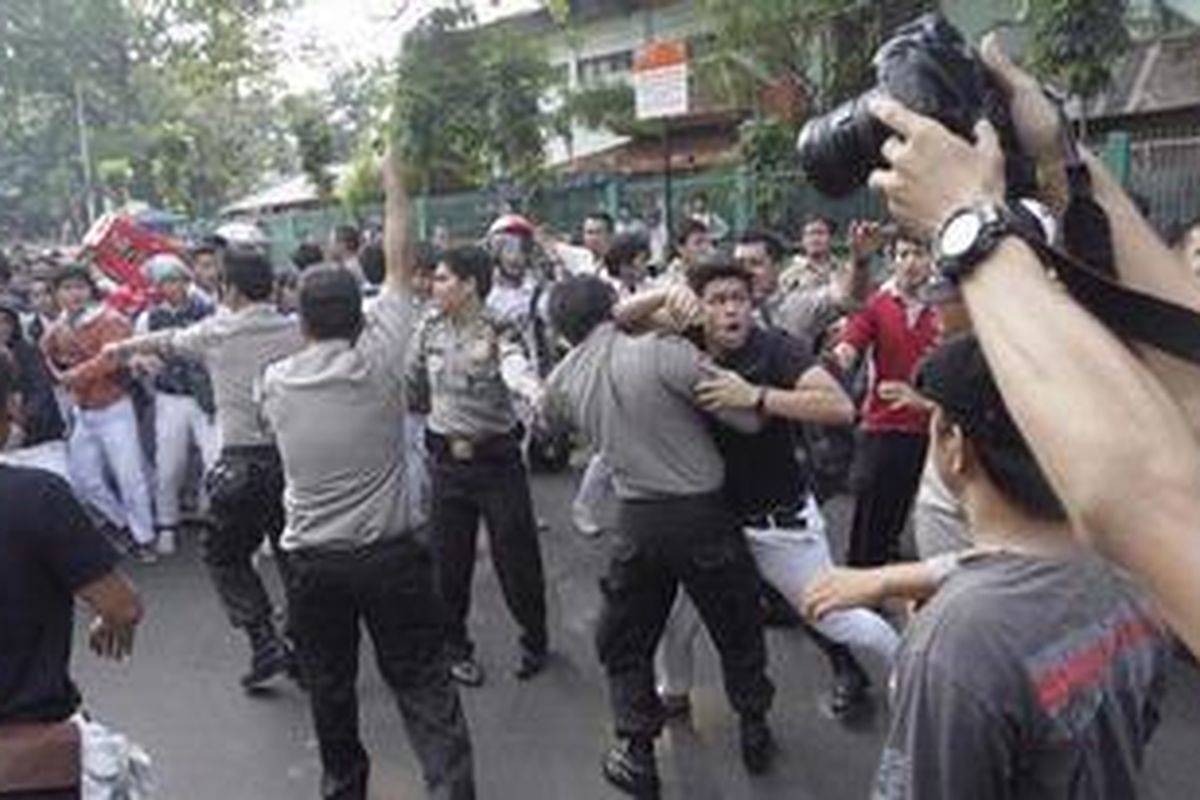 Siswa SMAN 6 dihalangi polisi dan sejumlah guru saat berhadapan dengan sejumlah wartawan di depan SMAN 6, Bulungan, Jakarta Selatan, Senin (19/9/2011). Kejadian ini bermula saat sejumlah wartawan melakukan aksi protes berkaitan dengan kasus perampasan kamera video salah satu wartawan Trans 7 saat meliput tawuran sekolah tersebut.