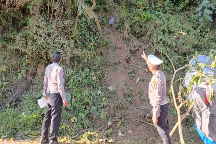 Polisi menunjukkan tebing jurang jip yang terjun di kawasan Bromo. 
