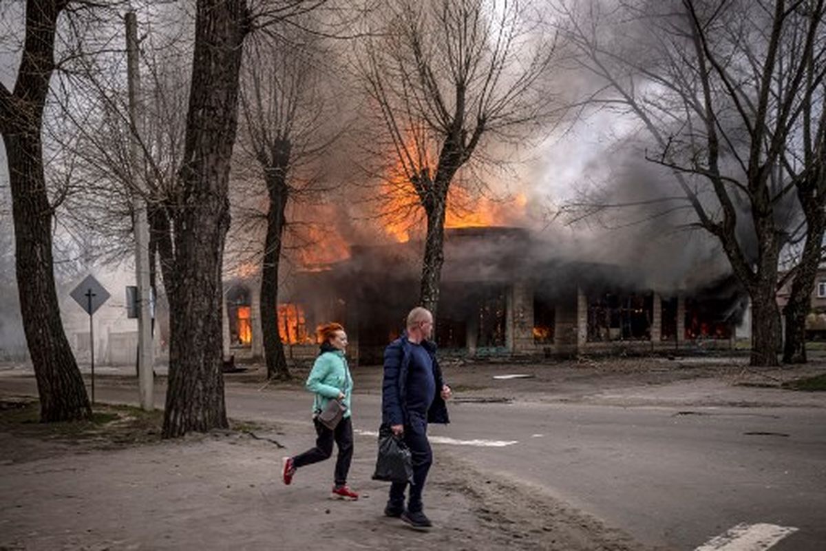 Warga berlarian di dekat sebuah rumah yang terbakar setelah penembakan di Severodonetsk, wilayah Donbass, pada 6 April 2022, ketika Ukraina memberi tahu penduduk di timur negara itu untuk mengungsi sekarang atau berisiko tinggi menjelang serangan gencar Rusia yang ditakuti di wilayah Donbas, yang Moskow telah mengumumkan hadiah utamanya.
