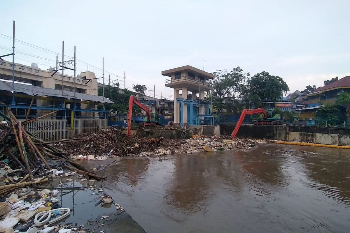 Proses pengangkatan sampah yang menumpuk di Pintu Air Manggarai, Jakarta Pusat (17/2/2022).