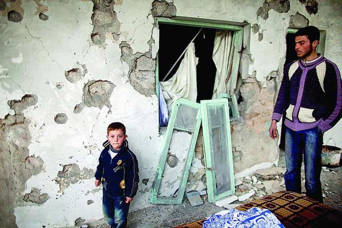 Warga Suriah berdiri di depan rumahnya yang hancur akibat pertempuran Tentara Suriah Bebas dan pasukan pemerintah yang setia kepada Presiden Bashar al-Assad, di Sarmin, utara Suriah, Selasa (28/2). Menurut penduduk setempat, sedikitnya 14 orang tewas sehari sebelumnya dalam bentrokan di antara kedua pasukan itu.