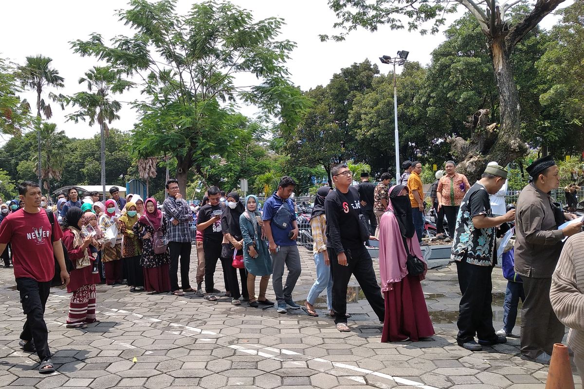 Warga antre untuk menukarkan uang baru di layanan kas keliling Bank Indonesia (BI) di Masjid Al Akbar Surabaya