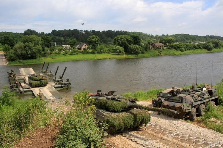Foto yang diambil pada 20 Juni 2017 ini memperlihatkan pasukan NATO melakukan latihan penyeberangan sungai dalam latihan perang Saber Strike 2017 di Stasenai, Lithuania. 
