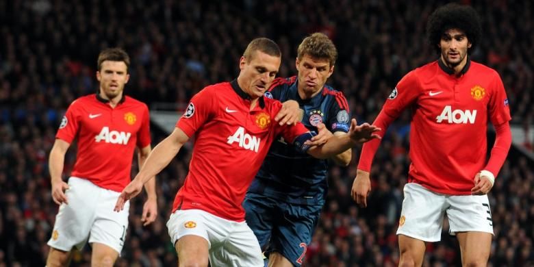 Bek Manchester United (MU), Nemanja Vidic, saat berebut bola dengan striker Bayern Muenchen, Thomas Mueller, pada leg pertama perempat final Liga Champions di Stadion Old Trafford, Selasa atau Rabu (2/4/2014) dini hari WIB. 