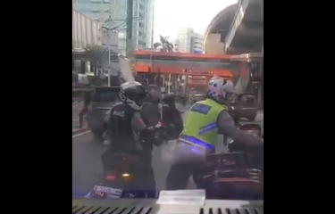Tangkapan layar video seorang polisi menilang motor pengawal ambulans.