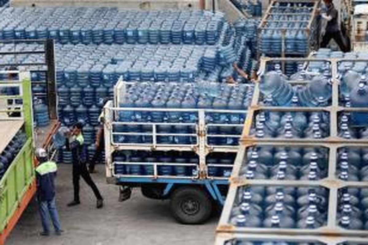 Karyawan perusahaan air minum dalam kemasan sedang bersiap mendistribusikan ratusan galon air ke dalam truk pengangkut.