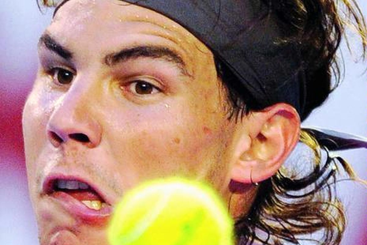 Petenis Spanyol, Rafael Nadal, mengamati datangnya bola pengembalian dari petenis Kroasia, Marin Cilic, pada pertandingan turnamen Australia Terbuka di Melbourne, Australia, Senin (24/1).