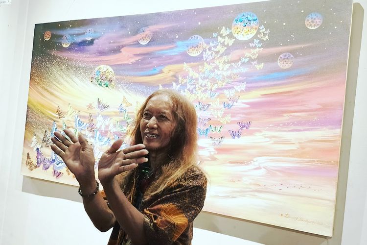 Pelukis asal Surabaya Buggy Budiyanto saat memberi penjelasannya di pameran tunggalnya memperingati Hari Kebangkitan Nasional di Galeri Dewan Kesenian Surabaya, Selasa (20/5/2025) malam.