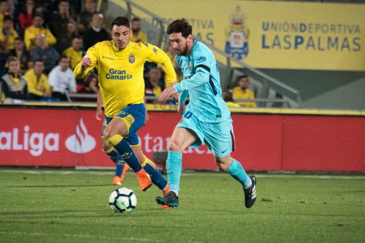 Striker utama Barcelona, Lionel Messi, mendapat pengawalan ketat dari pemain tuan rumah Las Palmas, Ximo Navarro Jimenez, dalam laga lanjutan Liga Spanyol di Stadion Gran Canaria, Kamis (1/3/2018). 