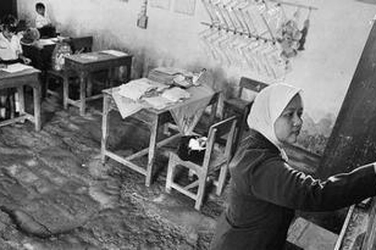 Ifadah Assolikhiyyah (35), guru honorer, mengajar para siswa SD Batu 2, Desa Batu, Kecamatan Karangtengah, Demak, Jawa Tengah, Selasa (6/3). Minimnya honor, sebesar Rp 100.000 per bulan, menyebabkan ibu dua anak ini juga membuka jasa merias pengantin di rumahnya untuk menambah pendapatan dan biaya kuliahnya.