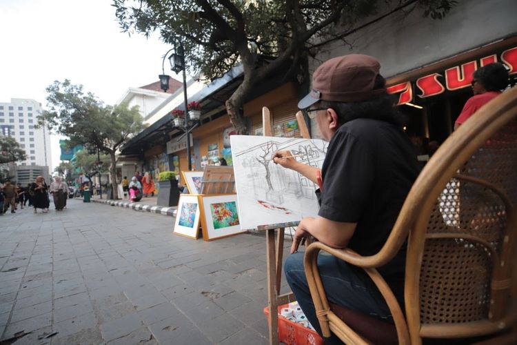 Seorang pelukis tengah menggambar keindahan Jalan Braga, Kota Bandung. 