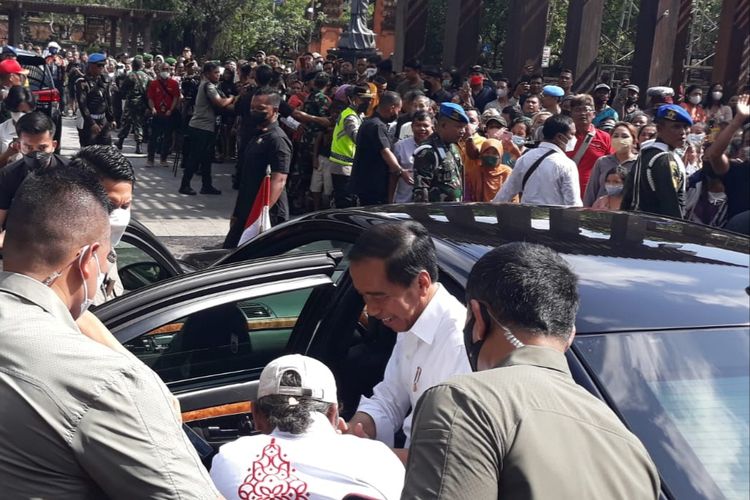 Komang Budiarta, langsung menundukkan badan sambil mencium tangan Presiden Joko Widodo sebagai tanda terima kasih usai menerima jaket G20 di Pasar Badung, Denpasar, Bali. Kompas.com/ Yohanes Valdi Sering Ginta