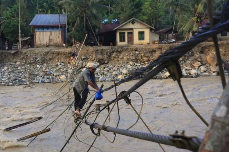 Warga melintasi jembatan alternatif yang menghubungkan Desa Blang Meurandeh di Desa Blang Puuk Beutong Ateuh Banggalang, Nagan Raya, Aceh, Minggu (30/11/2025). Pasca putusnya jembatan gantung diterjang banjir bandang pada Rabu (26/11) warga membuat jembatan darurat dari tali jembatan tersebut untuk jalur alternatif.