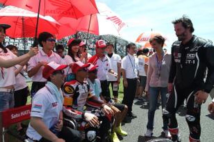 Aktor Amerika Serikat, Keanu Reeves (kanan), berbicara dengan pebalap tim Satu HATI Honda Team Asia sebelum start balapan Suzuka 8 Hours di Sirkuit Suzuka, Jepang, Minggu (26/7/2015).