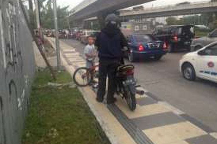 Bocah Daffa saat menegur Benny yang menuntut sepeda motornya di atas trotoar, Selasa (19/4/2016).