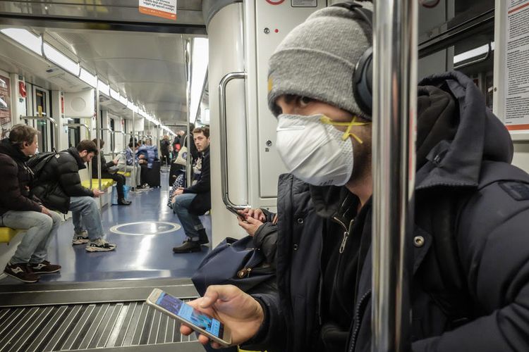 Seorang pria yang mengenakan masker melakukan perjalanan di metro Milan, Italia, 25 Februari. Virus corona saat ini menyebar hingga ke Brasil. 2020EPA-EFE/MATTEO CORNER