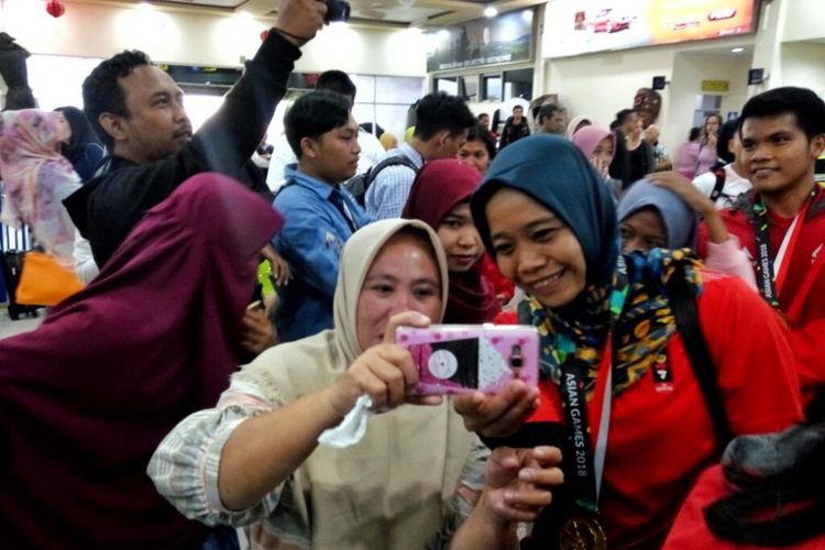 Salah satu atlet panjat tebing Indonesia Puji Lestari saat meladeni selfie warga di bandara Adisutjipto, Yogyakarta, Selasa (28/8/2018)