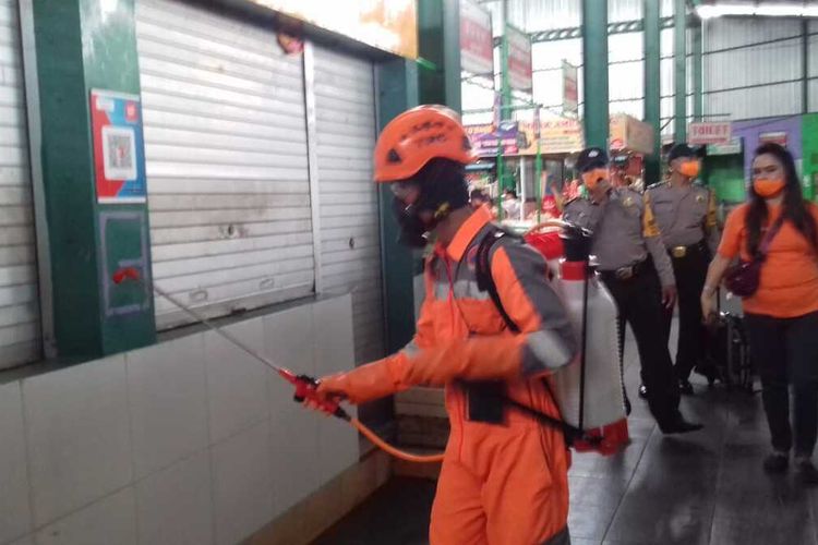 Petugas saat menyemprot cairan disinfektan di Pasar Oro-Oro Dowo, Kota Malang, Senin (23/3/2020).