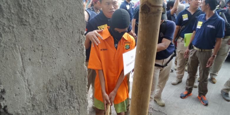 Tersangka pembunuh EF (19) yang masih di bawah umur, RA (16), memperagakan adegan mengambil pacul sebagai alat pembunuhan dalam rekonstruksi di mes karyawan PT Polyta Global Mandiri, Kosambi, Kabupaten Tangerang, Selasa (17/5/2016). 