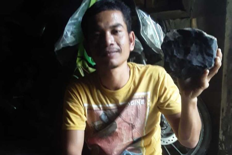 Josua Hutagalung (33), menunjukkan bongkahan batu yang diduganya benda langit (meteor) yang jatuh menimpa kediamannya di Dusun Sitahan Barat, Desa Satahi Nauli, Kecamatan Kolang, Kabupaten Tapanuli Tengah, Sabtu (1/8/2020).