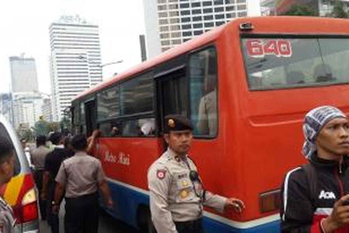 Massa diamankan terkait bentrok dengan polisi di Jalan Jenderal Sudirman, Jakarta Pusat, Selasa (1/12/2015).