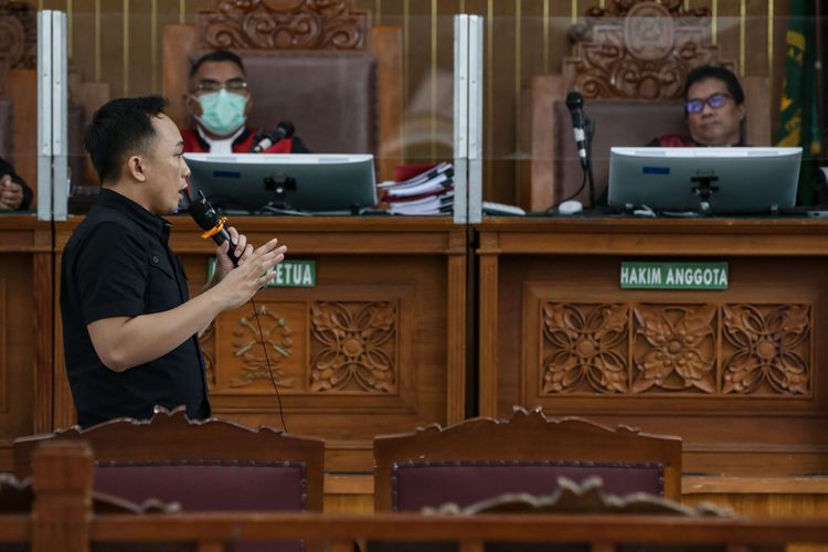 Terdakwa kasus pembunuhan berencana Brigadir J atau Nofriansyah Yosua Hutabarat, Ricky Rizal memeragakan adegan penembakan saat menjalani persidangan di Pengadilan Negeri Jakarta Selatan, Senin (9/1/2022).