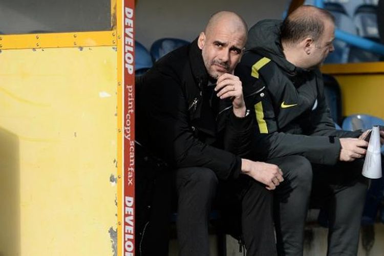 Manajer Manchester City, Josep Guardiola, sedang duduk di sisi lapangan sambil menunggu kick-off laga ronde kelima Piala FA antara timnya dan Huddersfield Town, di Stadion John Smith, Sabtu (18/2/2017).