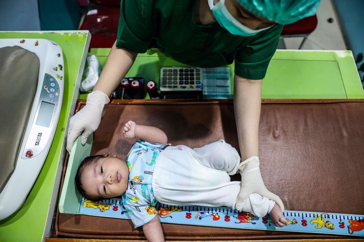 Perawat mengukur panjang tubuh badan bayi di ruang perawat poli anak di RSIA Tambak, Jakarta Pusat, Senin (22/6/2020). Dokter Poli Anak di RSIA Tambak berinisiatif menggunakan APD lengkap bertema khusus untuk memberikan kenyamanan kepada anak-anak yang menjalani pemeriksaan juga guna mengantisipasi penularan COVID-19.