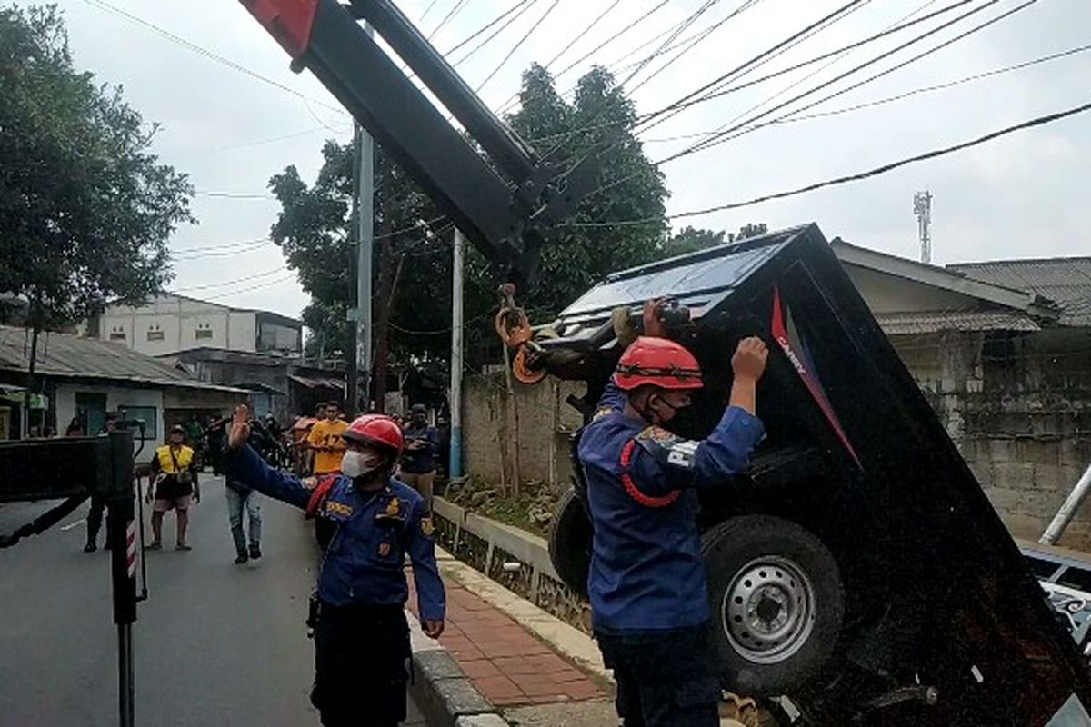 Petugas Pemadam Kebakaran dan Penyelamatan Jakarta Utara mengevakuasi mobil pikap yang tercebur ke selokan.   Peristiwa itu terjadi di Jalan Kelapa Dua Wetan, Ciracas, Jakarta Timur pada Senin (25/1/2021). 