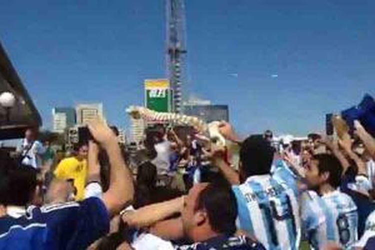 Fans Argentina terlihat bergembira sambil mengangkat tiruan tulang belakang, sebagai bentuk ejekan terhadap striker Brasil, Neymar, yang mengalami cedera retak tulang belakang saat membawa Brasil kalahkan Kolombia 2-1 di perempat final Piala Dunia 2014, 4 Juli 2014.