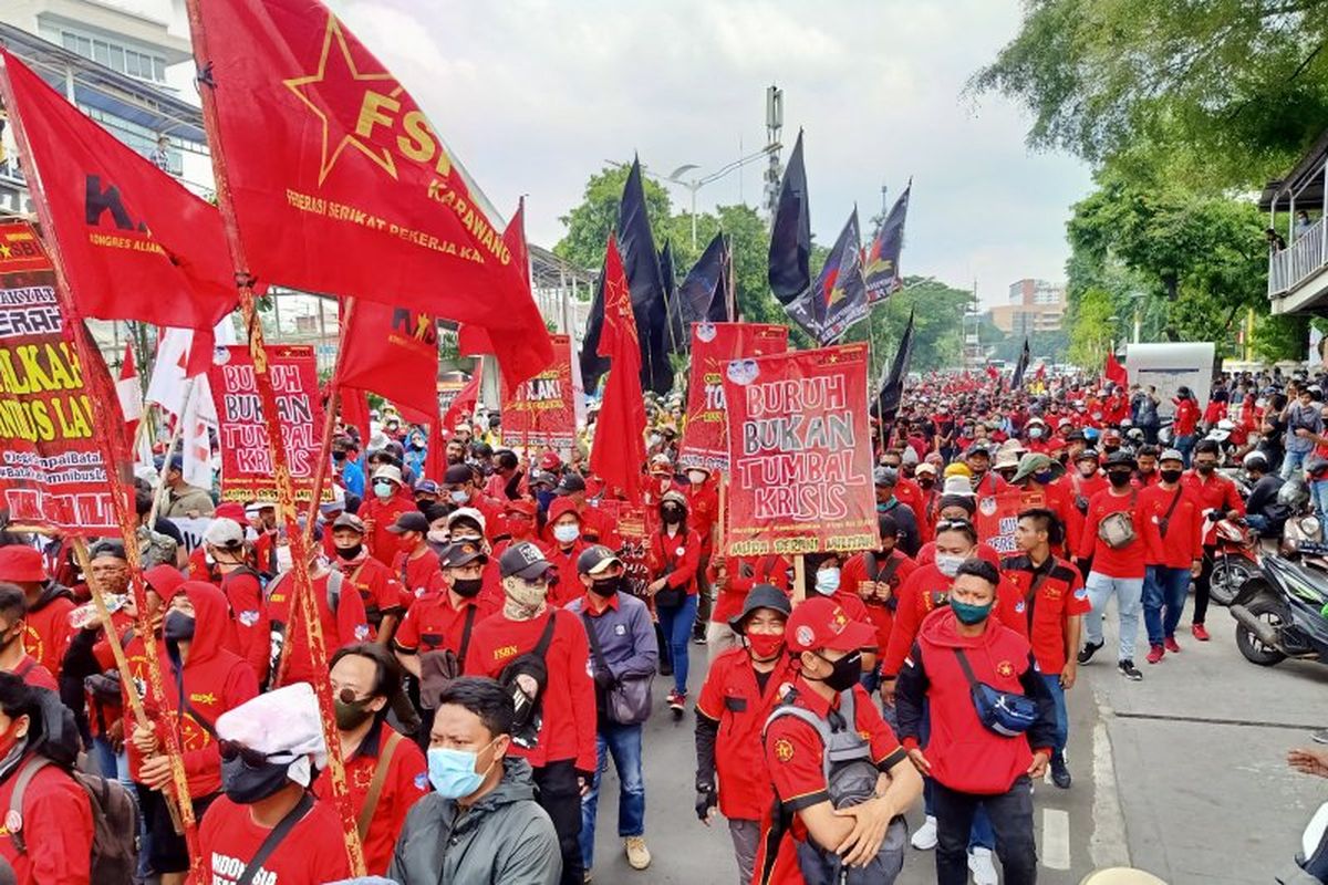 Massa buruh berjalan kaki di Jalan Salemba Raya, Jakarta Pusat, menuju kawasan Monas dalam rangkaian aksi penolakan Undang-Undang Cipta Kerja, Selasa (20/10/2020).