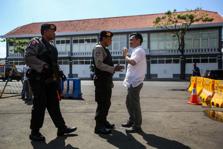 Petugas kepolisian memeriksa dokumen pengunjung di pintu masuk Polrestabes, Surabaya, Jawa Timur, Selasa (15/5/2018). Ledakan yang melukai empat anggota polisi dan enam warga terjadi pada Senin (14/5/2018) pagi di depan pos penjagaan pintu masuk Polrestabes Surabaya.