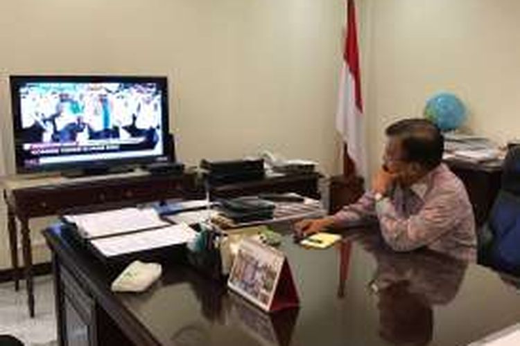 Wakil Presiden Jusuf Kalla tengah menyaksikan jalannya doa bersama melalui siaran langsung televisi di ruang kerjanya, Jumat (2/12/2016). 