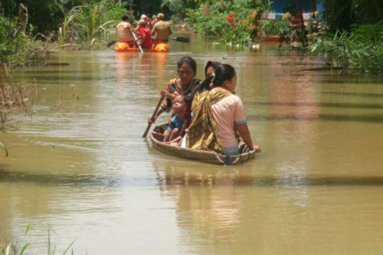 Warga yang terendam banjir di Kecamatan Bonai Darussalam, Rohul, Riau, menggunakan perahu tradisional saat beraktivitas, Kamis (18/10/2018).