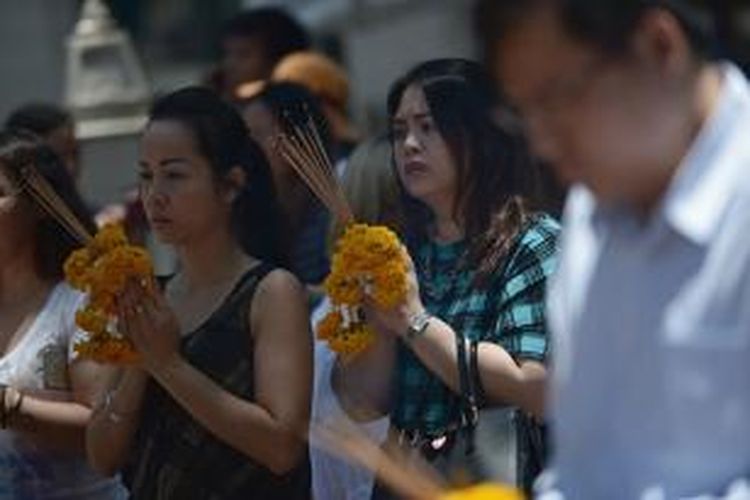 Warga Thailand memanjatkan doa dalam upacara pembukaan kembali Kuil Erawan, Rabu (19/8/2015), pasca-serangan bom dua hari sebelumnya.