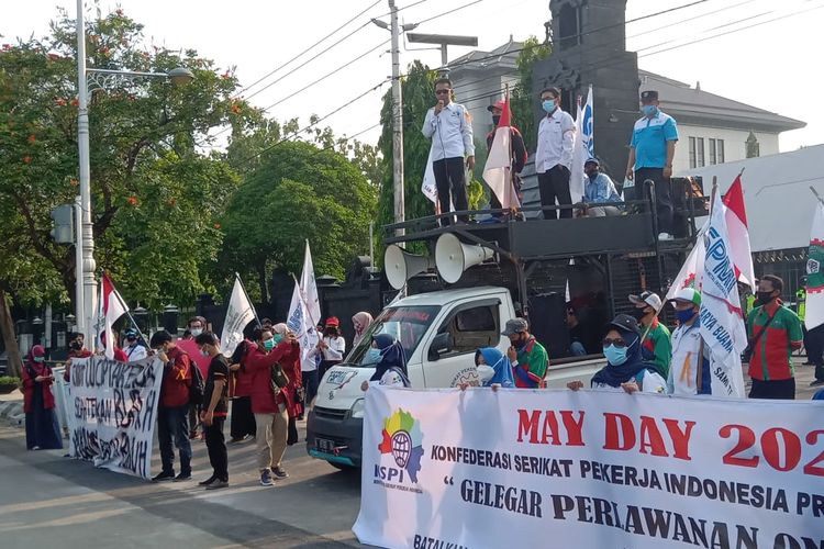 Workers stage a protest to mark international labor day in front of the office of the Central Java governor on Saturday, May 1, 2021.  