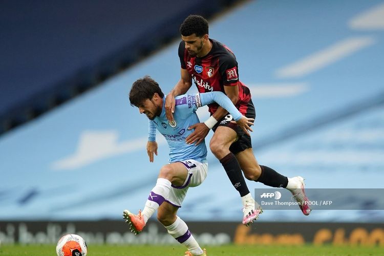 David Silva (kiri) dan penyerang Bournemouth, Dominic Solanke, berebut bola dalam pertandingan Man City vs Bournemouth di Stadion Etihad, Kamis (16/7/2020) dini hari WIB. 
