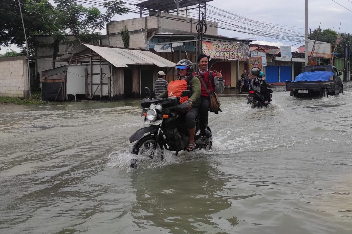 Pengendara motor melintas di genangan banjir Jalan Raya Purwodadi-Semarang, tepatnya di area Kantor Kecamatan Kebonagung, Kabupaten Demak, Jawa Tengah (Jateng), Rabu (22/1/2025).