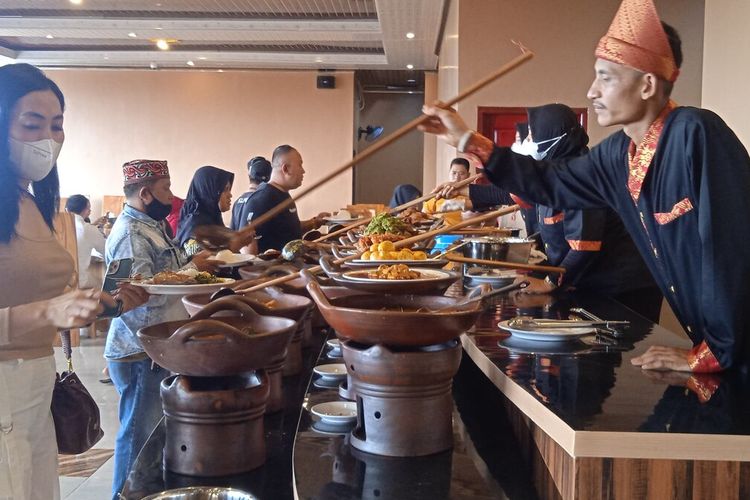 Pegawai Nasi Kapau Bagindo menuangkan lauk yang dipilih oleh pengunjung, Selasa (22/6/2022). Nasi Kapau Bagindo menyajikan lebih dari 50 pilihan menu khas Tanah Minang.