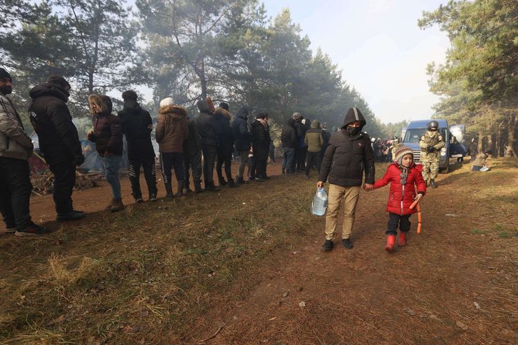 Para migran mengantre untuk menerima bantuan kemanusiaan yang dikirimkan oleh Palang Merah Belarusia dan pejabat negara di sebuah kamp di perbatasan Belarusia-Polandia, Rabu (10/11/2021). Polandia dan negara-negara Uni Eropa (UE) menuduh Belarusia mendorong para migran untuk secara ilegal melintasi perbatasan sebagai pembalasan atas sanksi yang dijatuhkan UE kepada Minsk atas pelanggaran HAM.