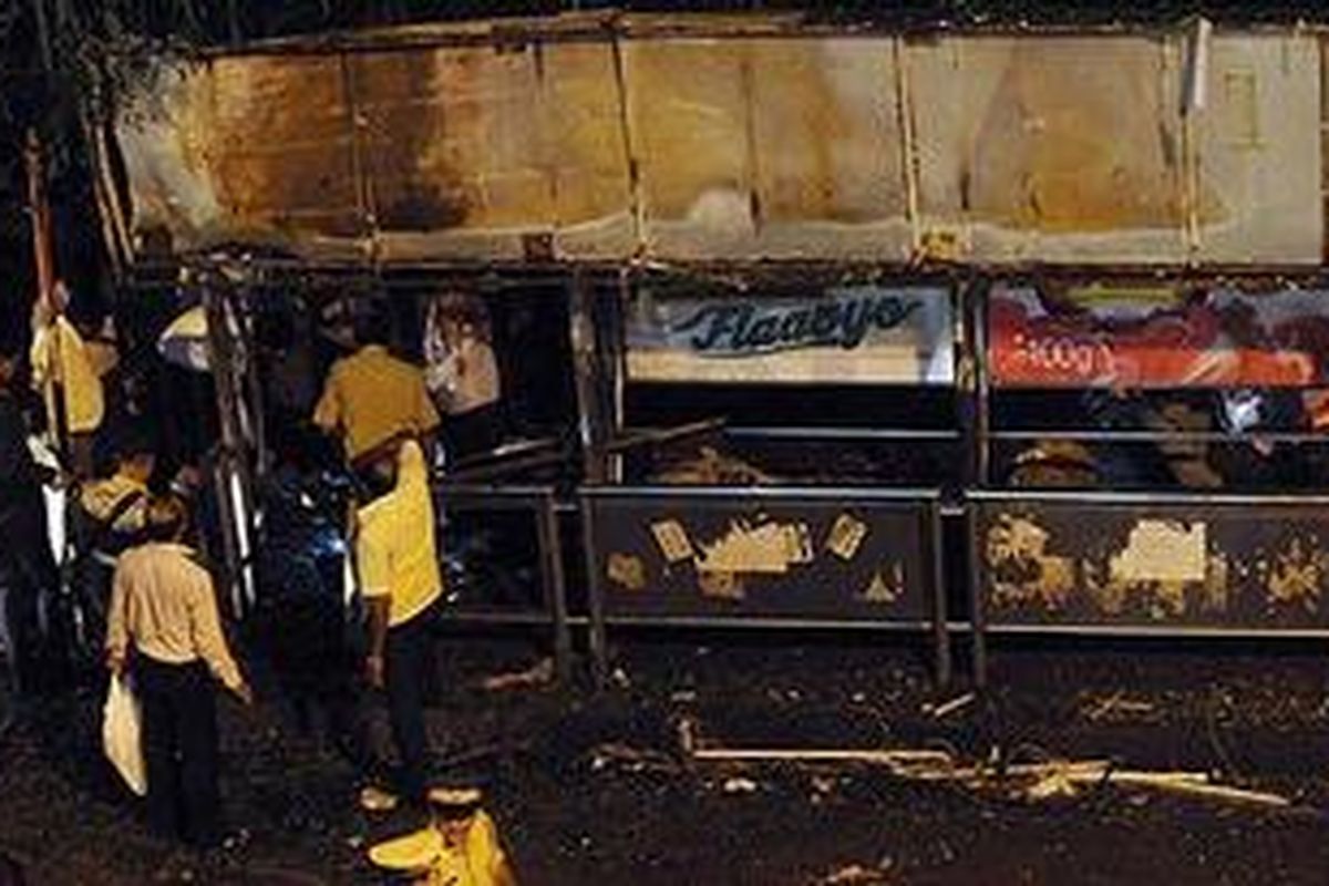 Polisi memeriksa lokasi ledakan di halte bus di distrik Dadar, Rabu (13/7/2011) malam.