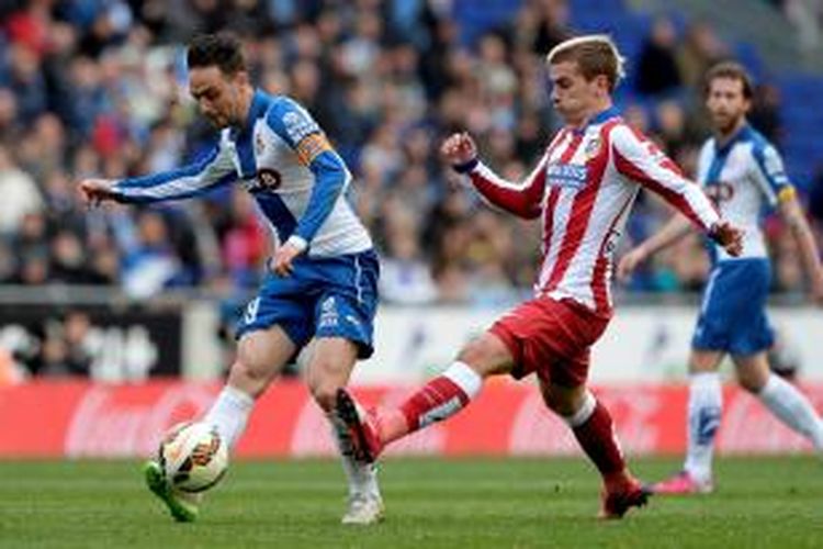 Gelandang Atletico Madrid, Antoine Griezmann (kanan), saat berupaya memblok bola tendangan striker Espanyol, Sergio Garcia, pada lanjutan Primera Division, di Stadion Cornella-El Prat, Sabtu (14/3/2015).