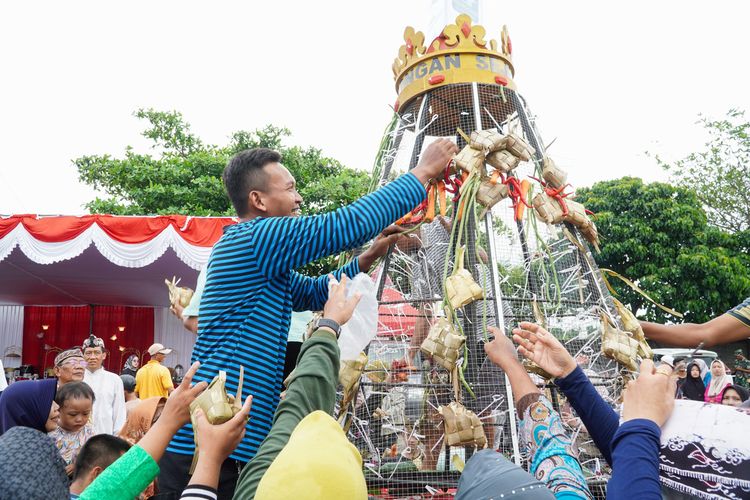 Warga berebut gunungan ketupat saat Festival Kupatan Tanjung Kodok 2024 di halaman parkiran Wisata Bahari Lamongan (WBL), Rabu (17/4/2024).