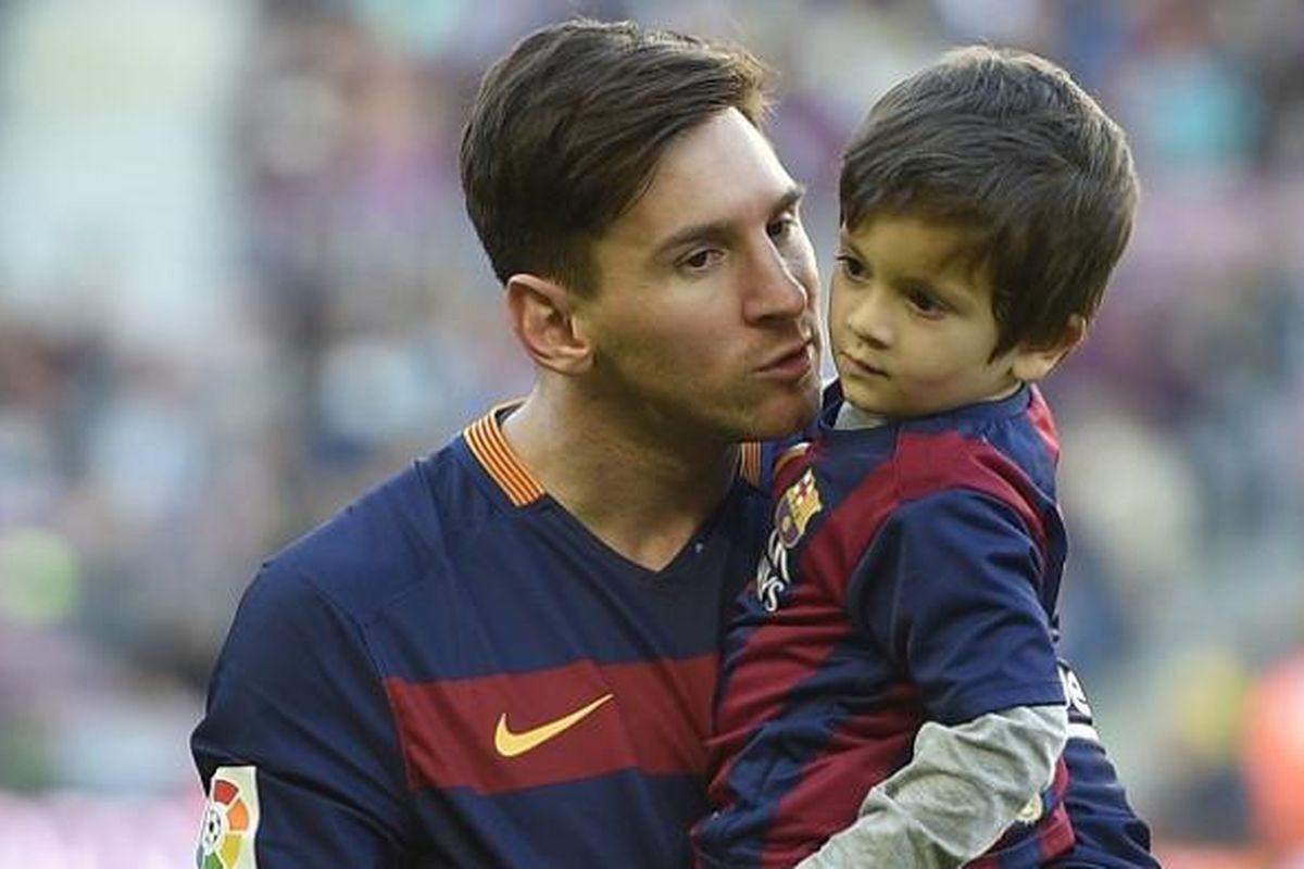 Pemain FC Barcelona, Lionel Messi, menggendong anaknya, Thiago, menjelang laga kontra Real Sociedad di Stadion Camp Nou, pada 28 November 2015.